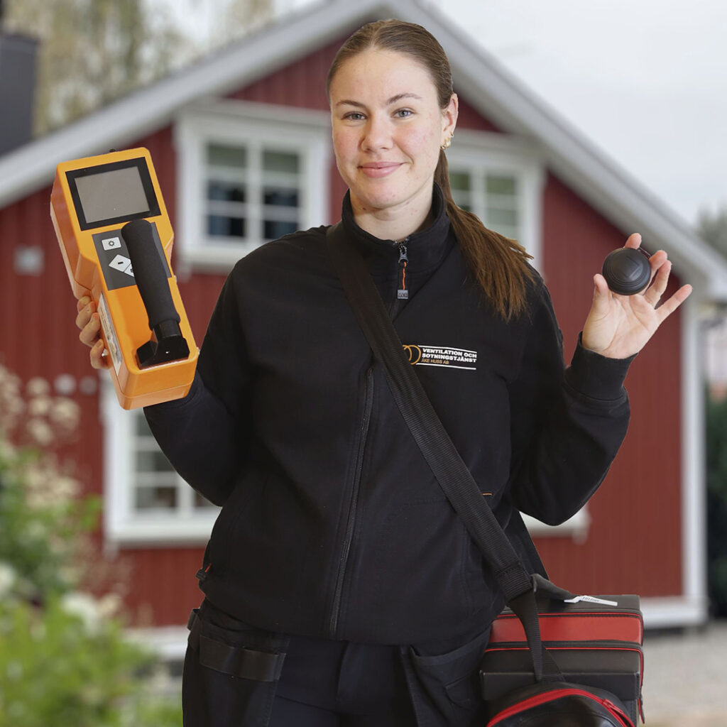 Tjej från Åke Huss håller i radonmätare