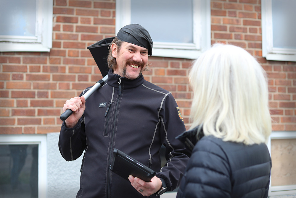 Anställd på Åke Huss pratar med kund efter ventilationskontroll